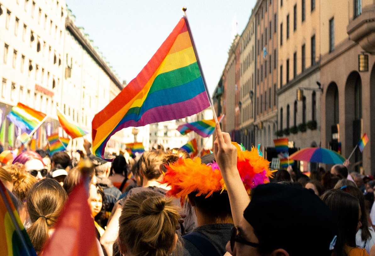 Pride parade with rainbow flags.
