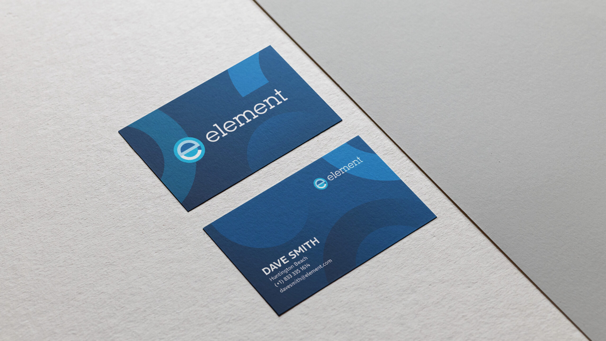 Stationery mockup showing the front and back design of blue Element business cards with abstract geometric patterns and contact details for Dave Smith.